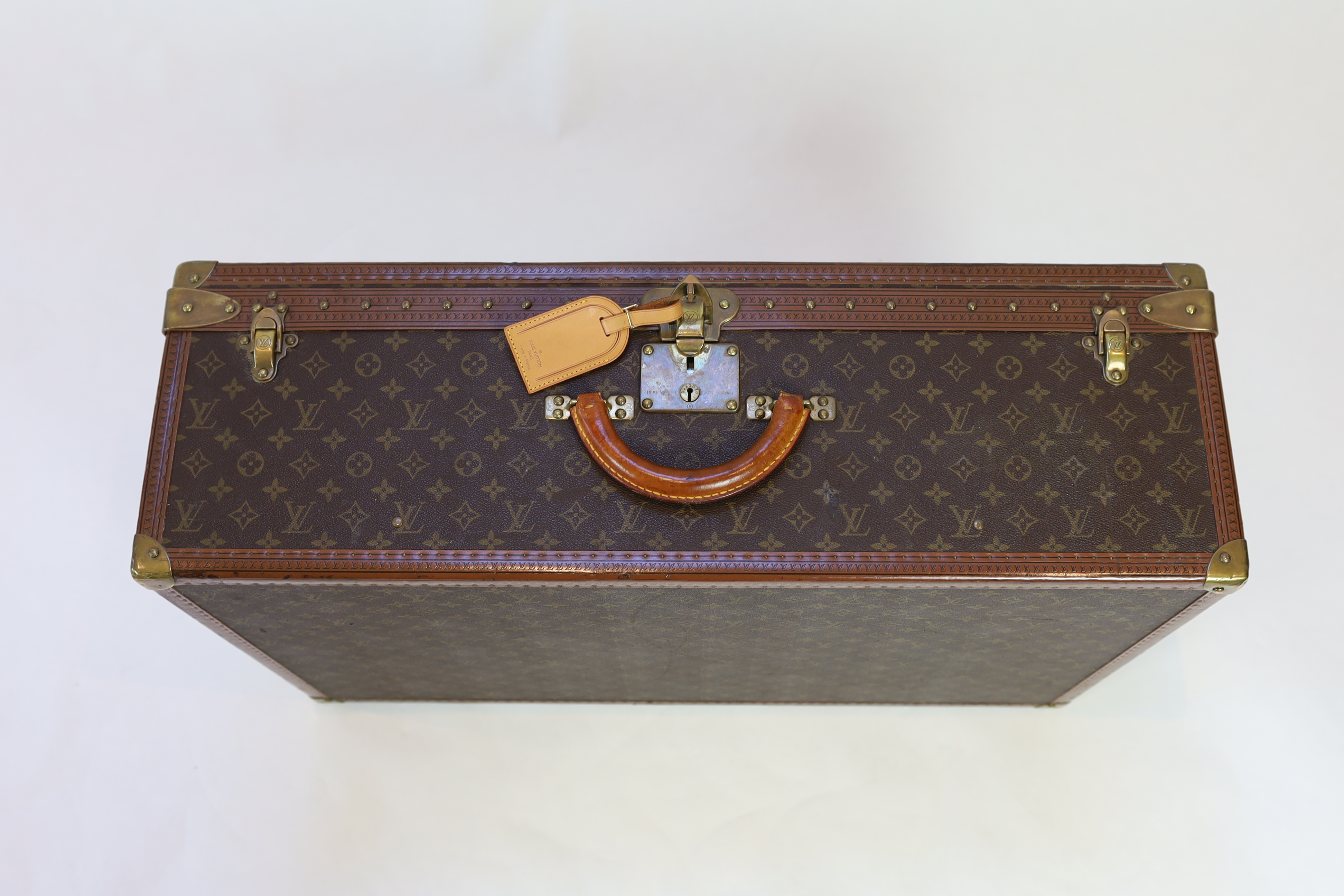 A Louis Vuitton monogram canvas and tan leather suitcase, width 81cm, depth 26cm, height 52cm